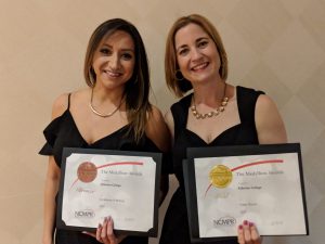 Melissa Serrato and Lisa McPheron each hold a Medallion Award