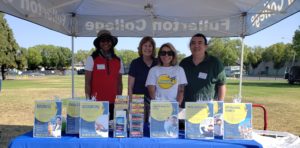 Professor Earle, Paulette Chaffee, Nicole Cintron, and Professor Kim greet guests at a booth at the Juneteenth event